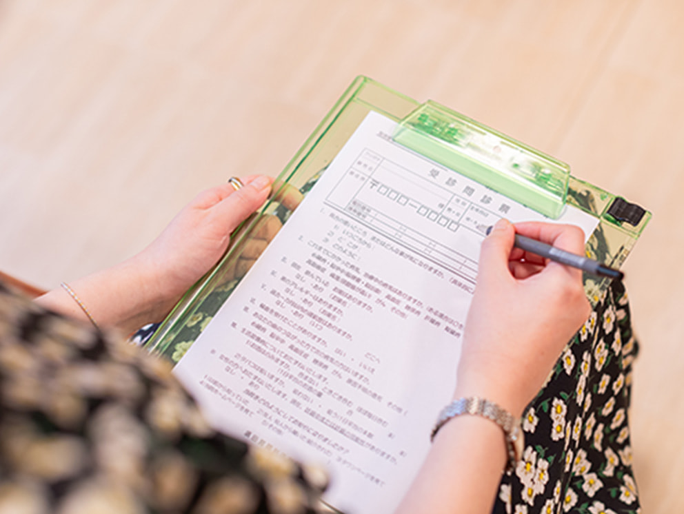 診療用の問診票に記入している様子