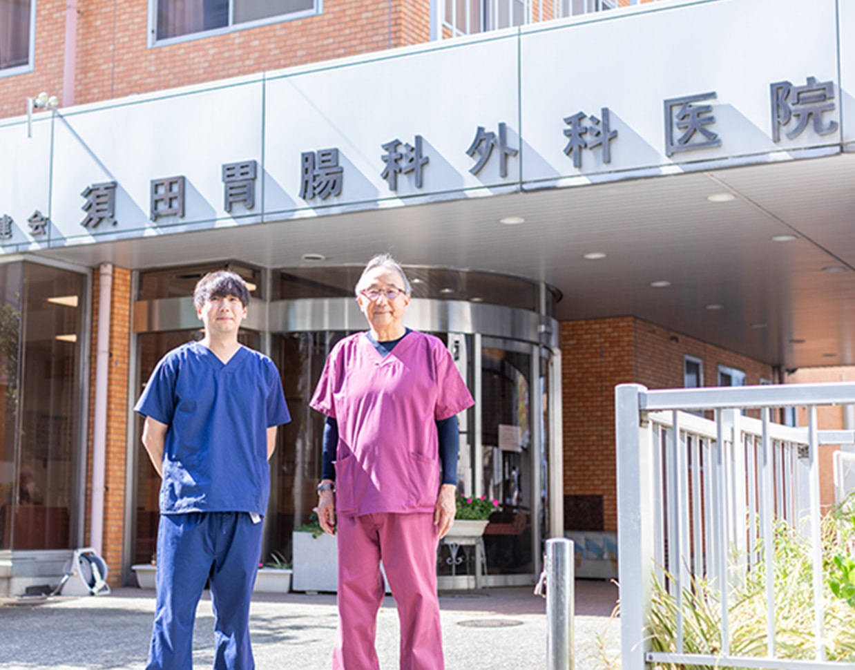病院の前に立つ医師が2名並んでいる写真